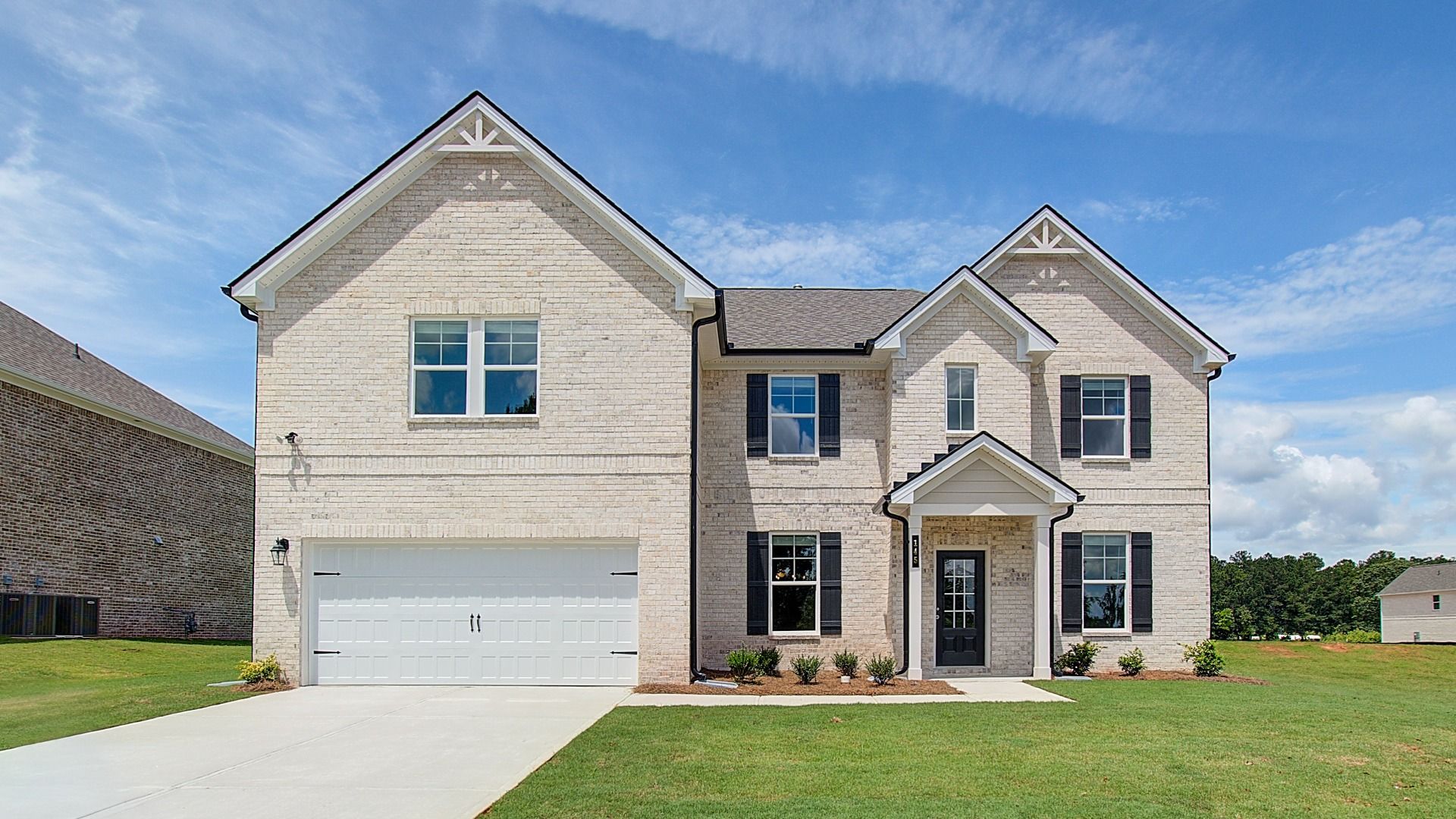 McKinley II four-sided light brick exterior with dark shutters and front-entry garage at Westwind Estates in Hampton, GA.