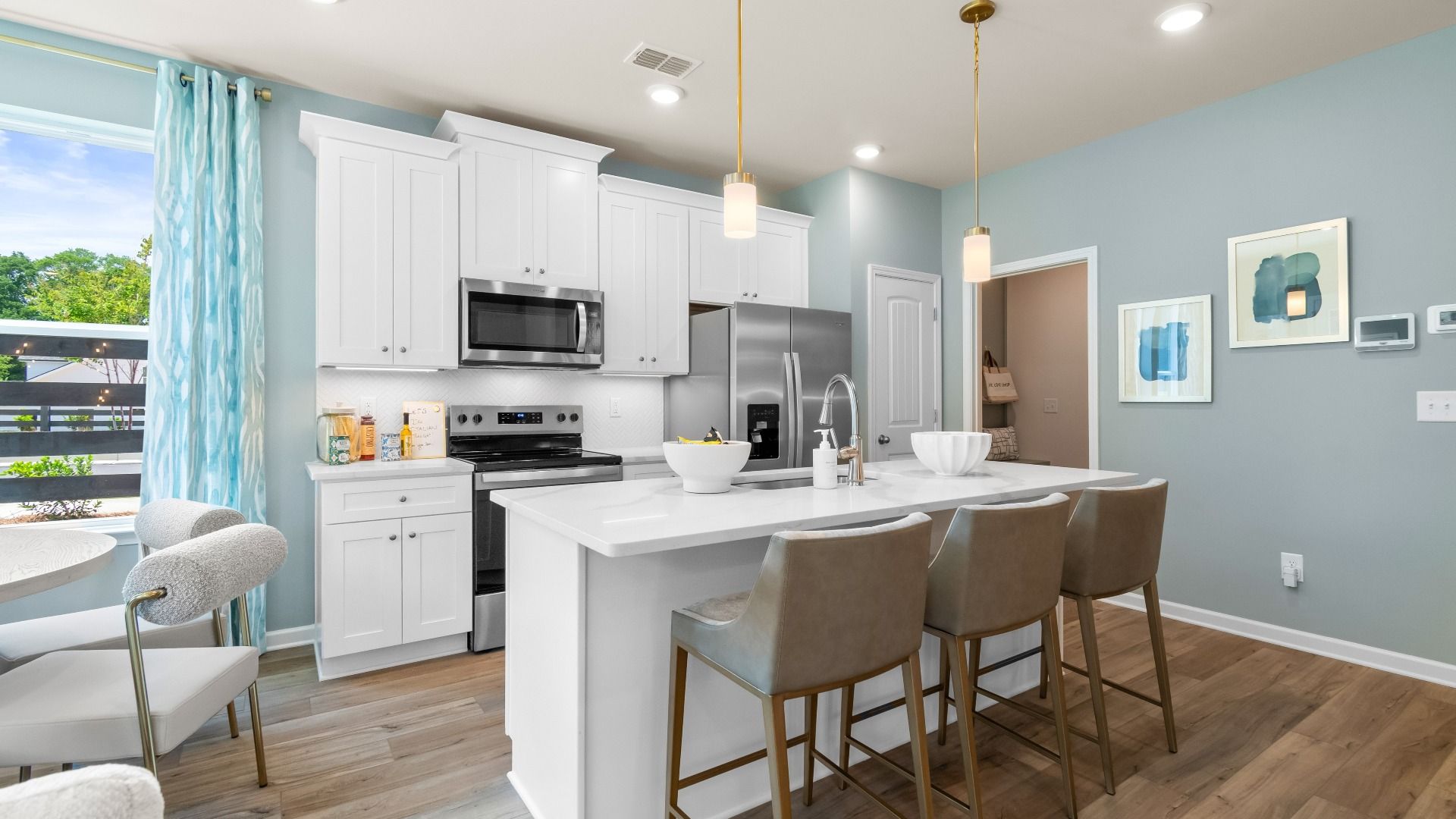 Modern kitchen with quartz island, stylish backsplash, stainless appliances, and ample cabinet storage.