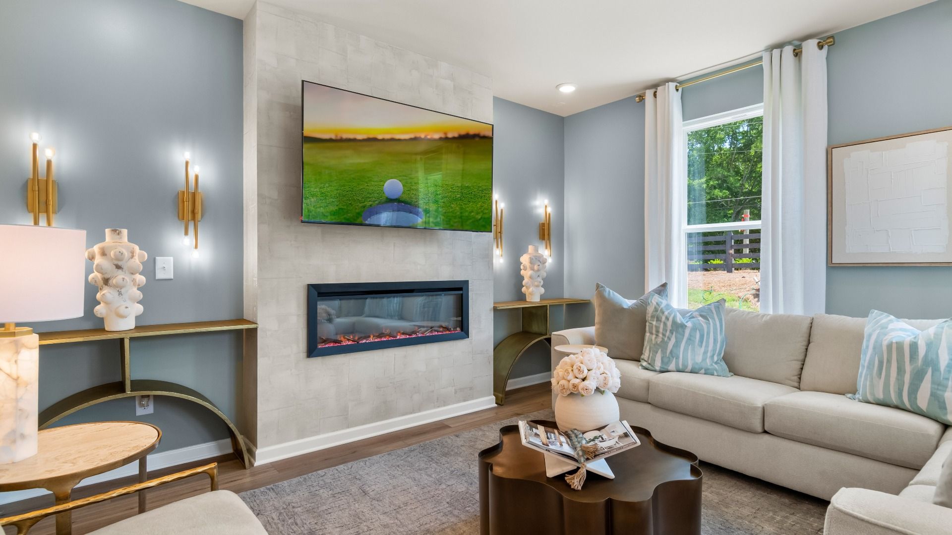 Spacious family room with electric fireplace, large windows, and open layout in new construction townhome.