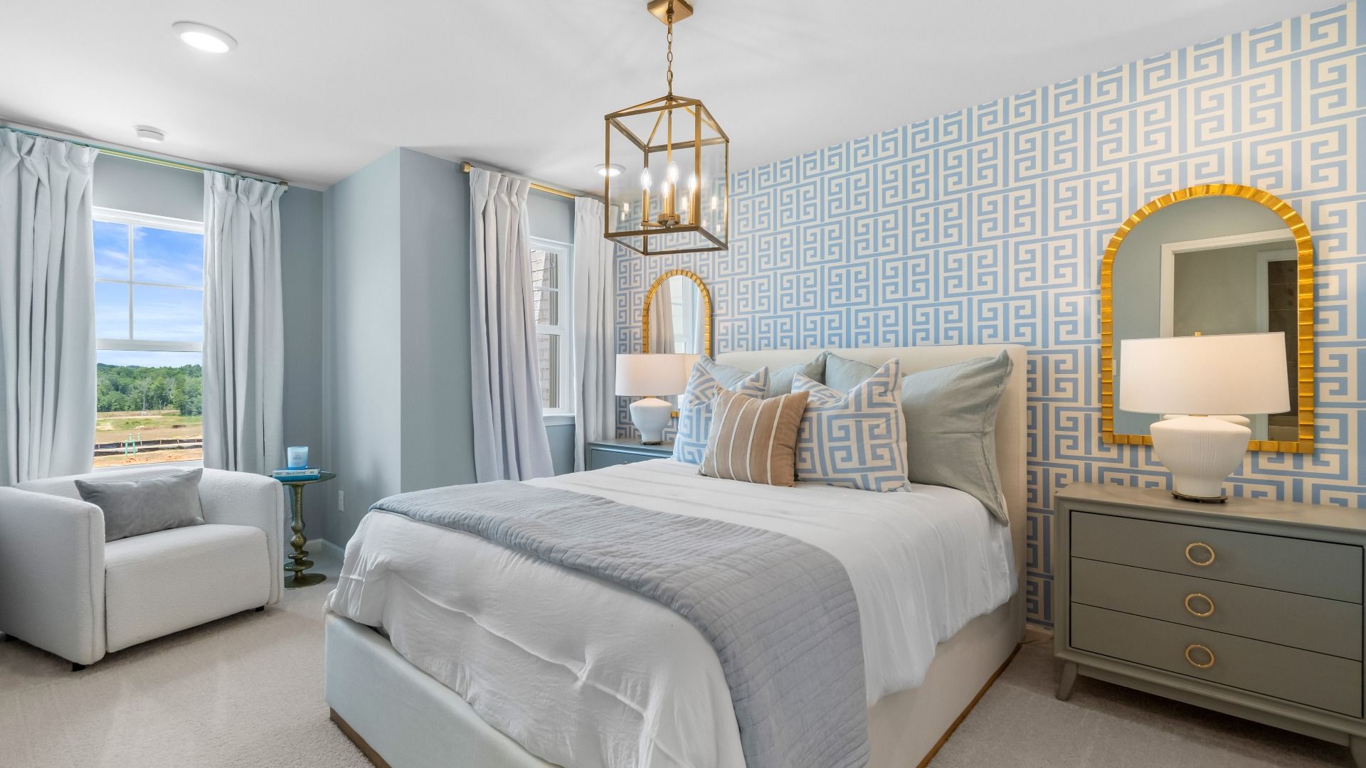 Sophisticated secondary bedroom with blue geometric wall and gold lantern pendant in Abbotts Crossing Towns, Conyers, GA.