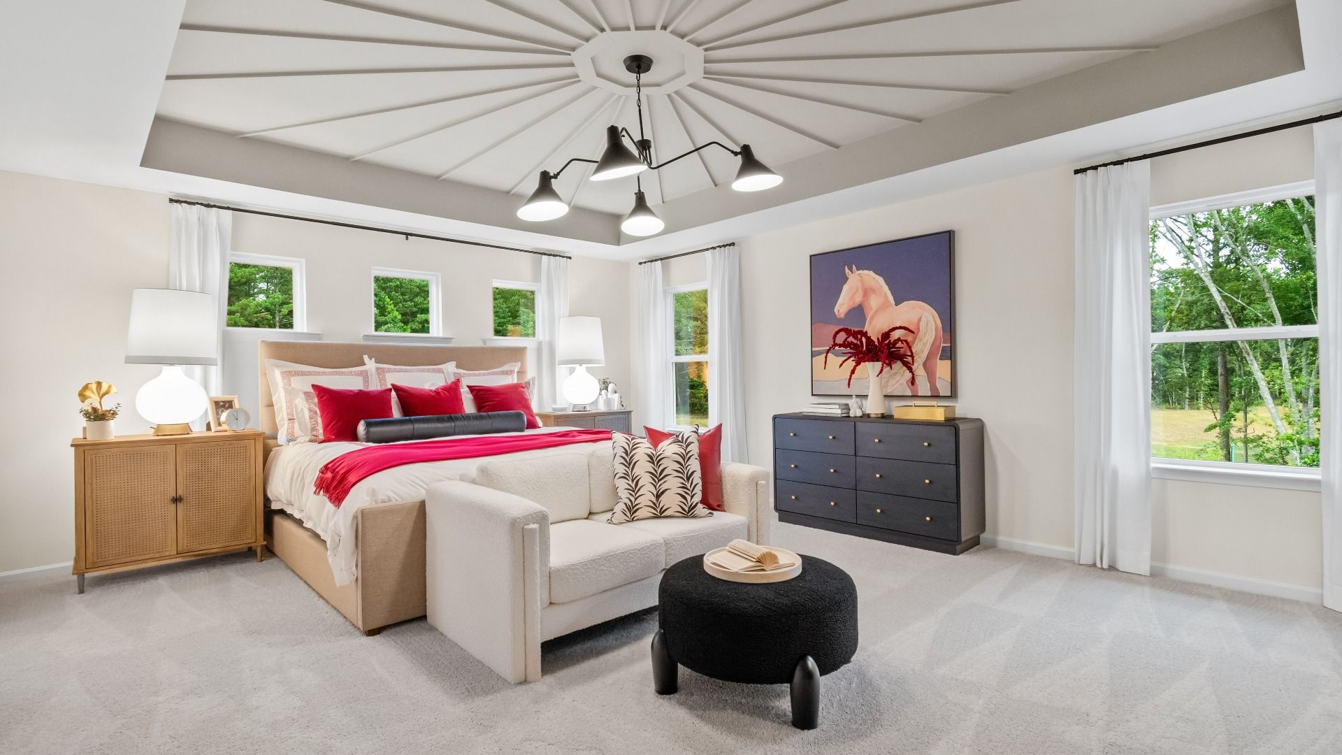 Spacious primary suite with unique tray ceiling, carpeted floors, and natural light in Hamilton Lakes in Lawrenceville, GA.