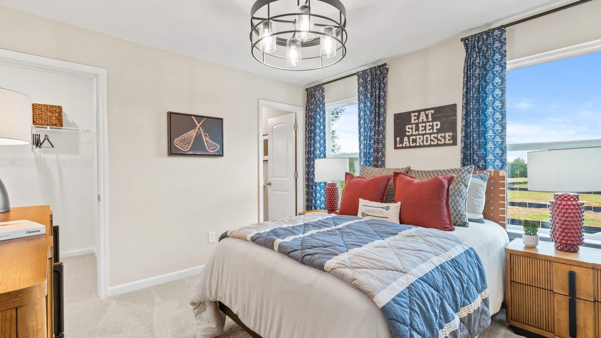 Wynwood secondary bedroom with carpet flooring, natural light, and attached closet and bathroom at Abbotts Crossing.