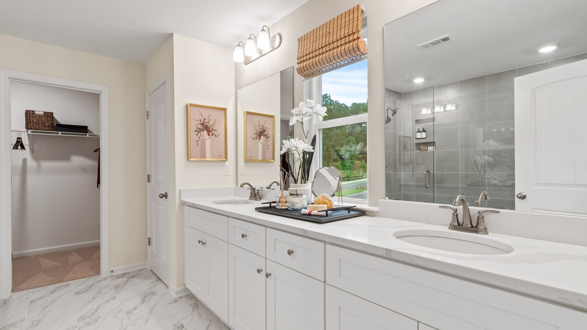 Wynwood primary bath with dual vanities and luxury flooring at Abbotts Crossing in Conyers, GA.