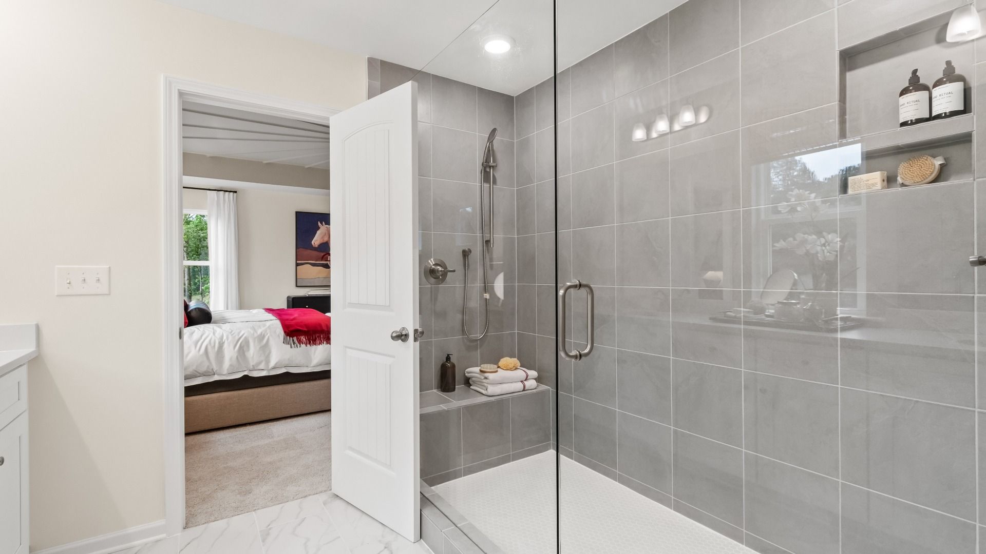 Wynwood primary bath featuring generously-sized walk-in shower with tile walls at Abbotts Crossing in Conyers, GA.