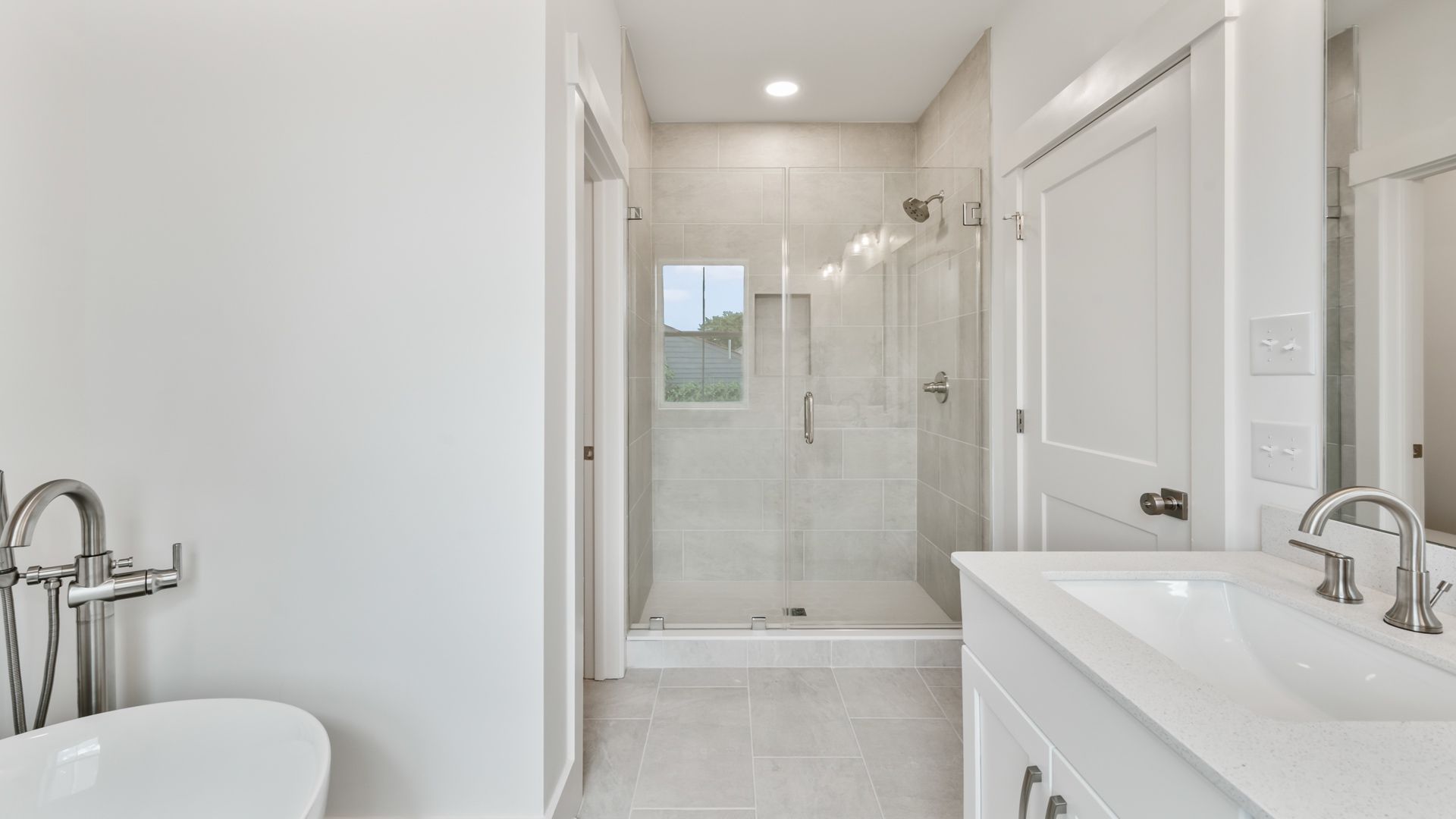 Spacious primary bathroom in the Sullivan home plan featuring dual vanities, a walk-in shower, and elegant details.