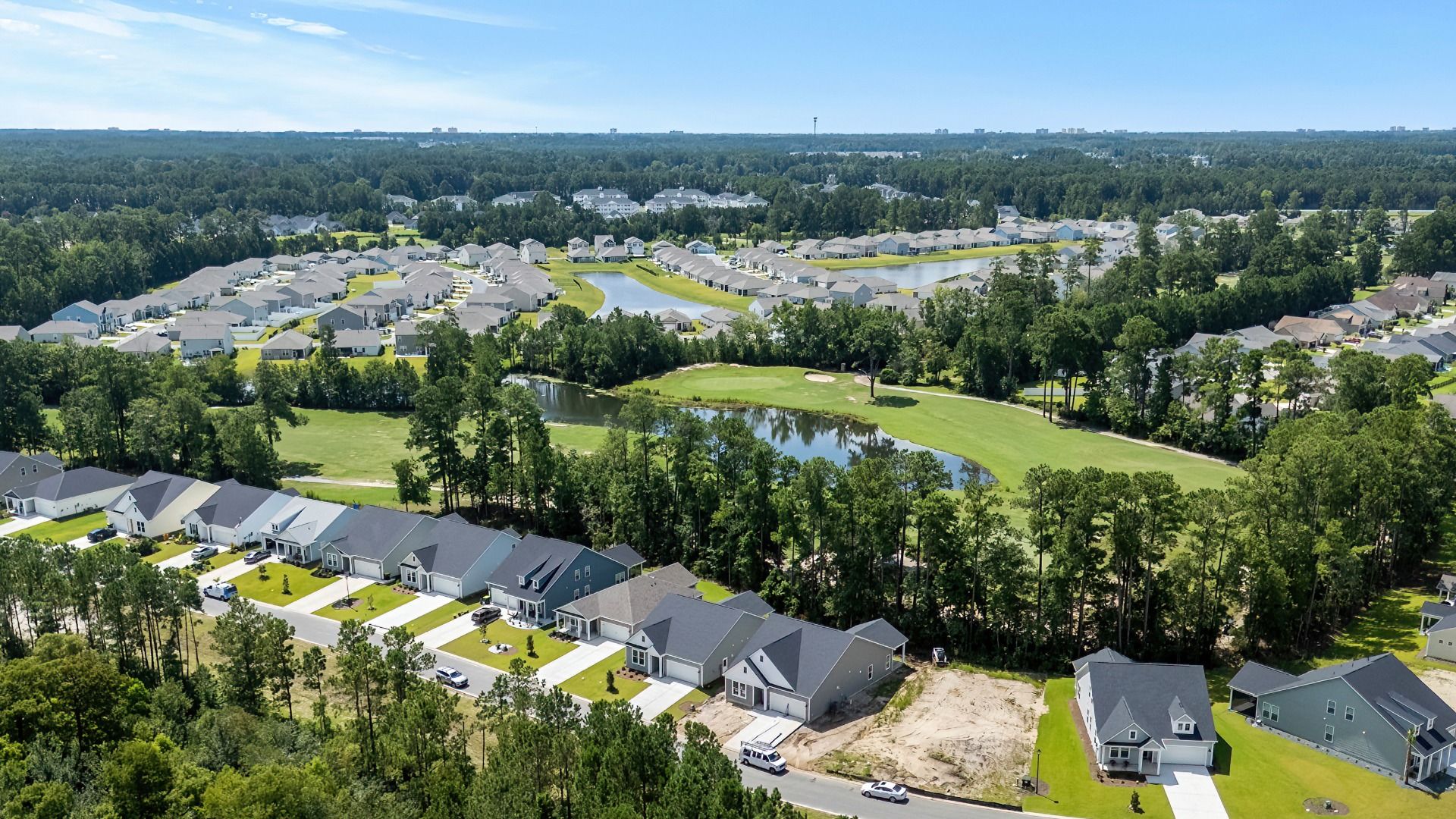 Aerial views of Bluffs at Sun Colony with water and wooded homesites on golf course.