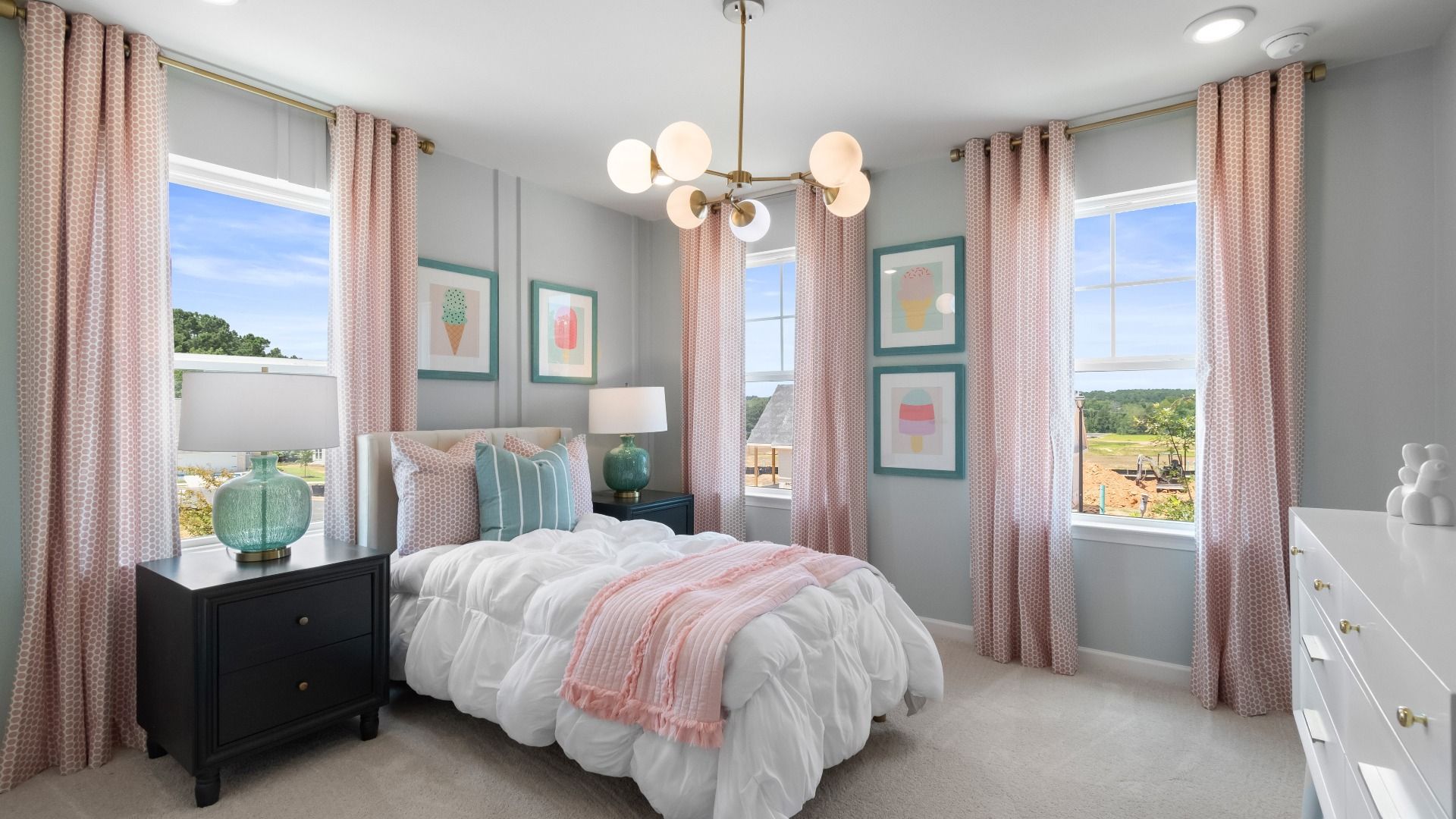 Bright girl's bedroom with pink curtains and ice cream art in DRB Homes' townhome at Abbotts Crossing Towns.
