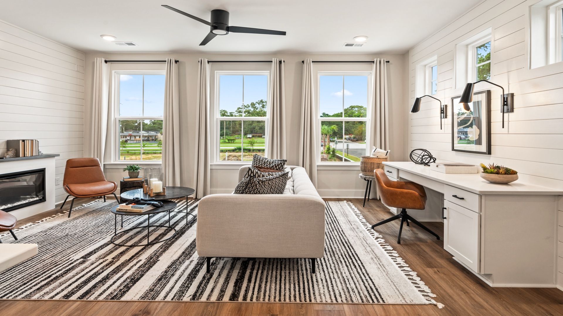 Spacious living room with large windows and built-in workspace