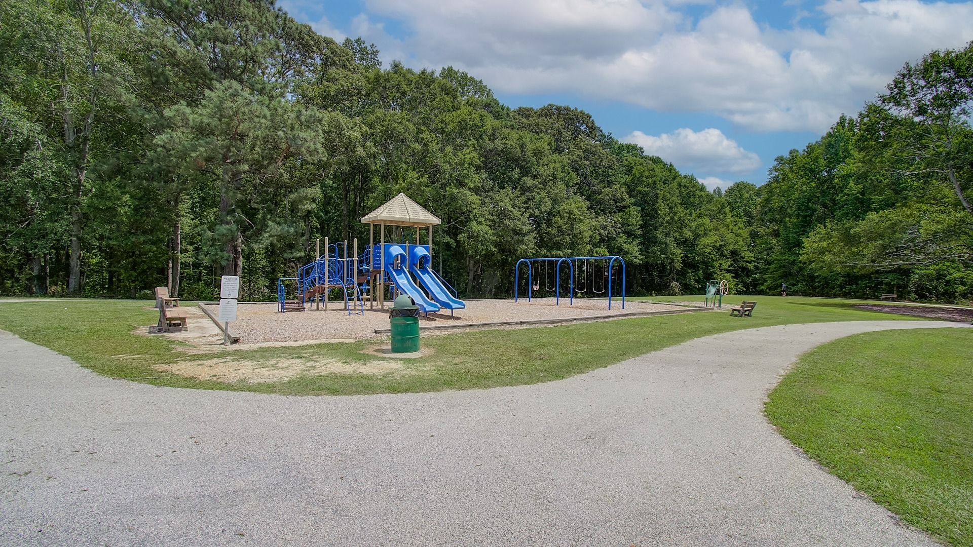 Community playground with bench seating and walking path near Northcroft in Loganville, GA.