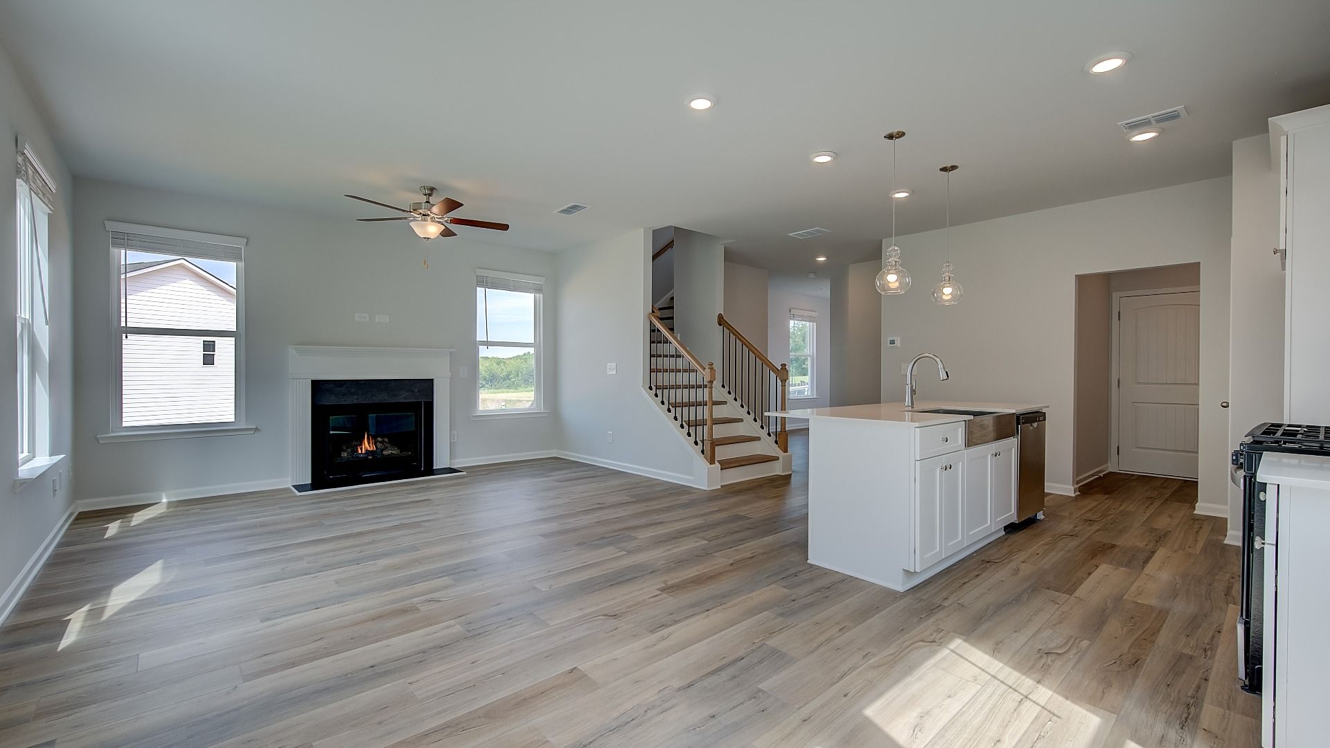 Open family room with abundant natural light and seamless flow to kitchen in new construction home.