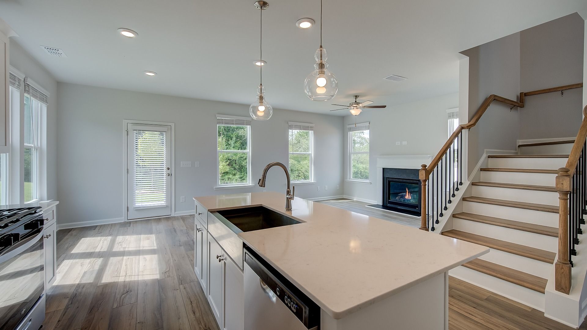 Spacious kitchen open to family room and stairs featuring modern design and neutral finishes.