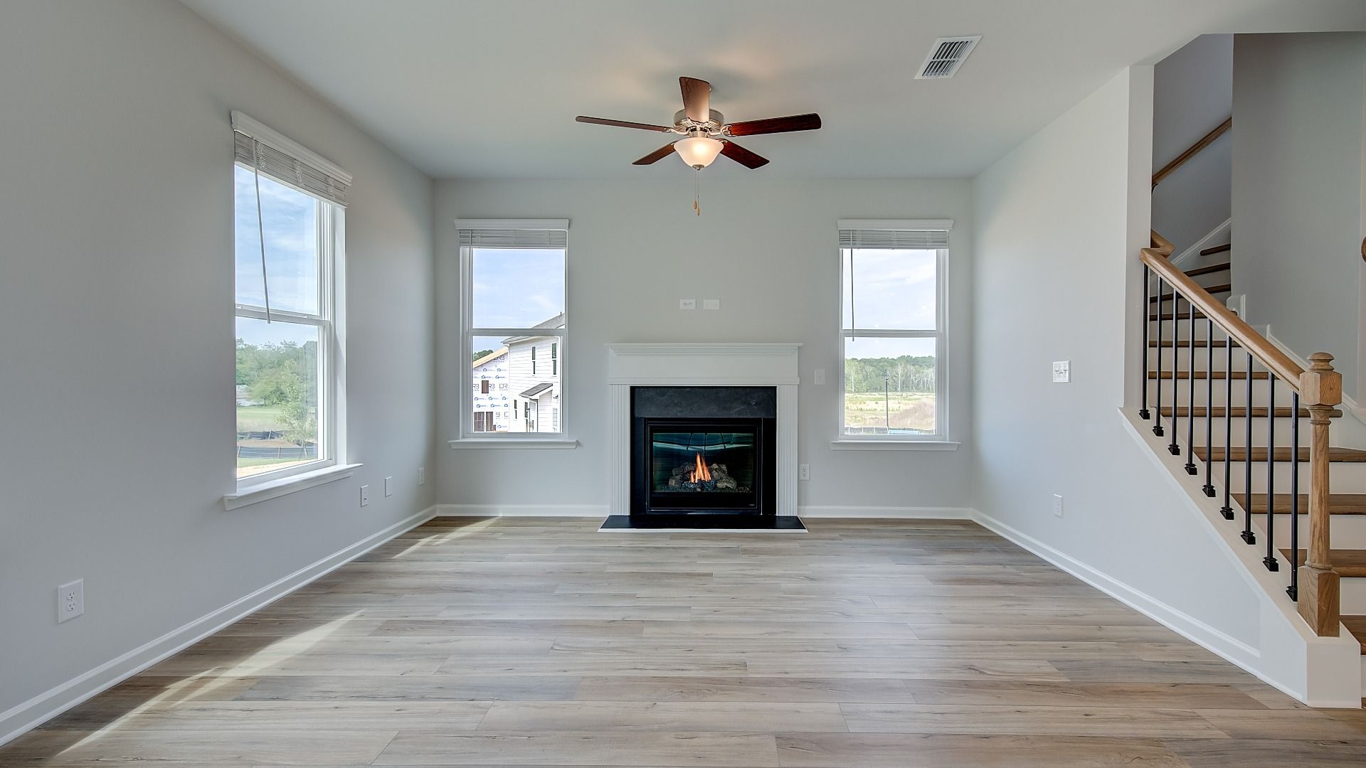 Spacious family room featuring modern gas fireplace with LVP flooring in Conyers, GA home.