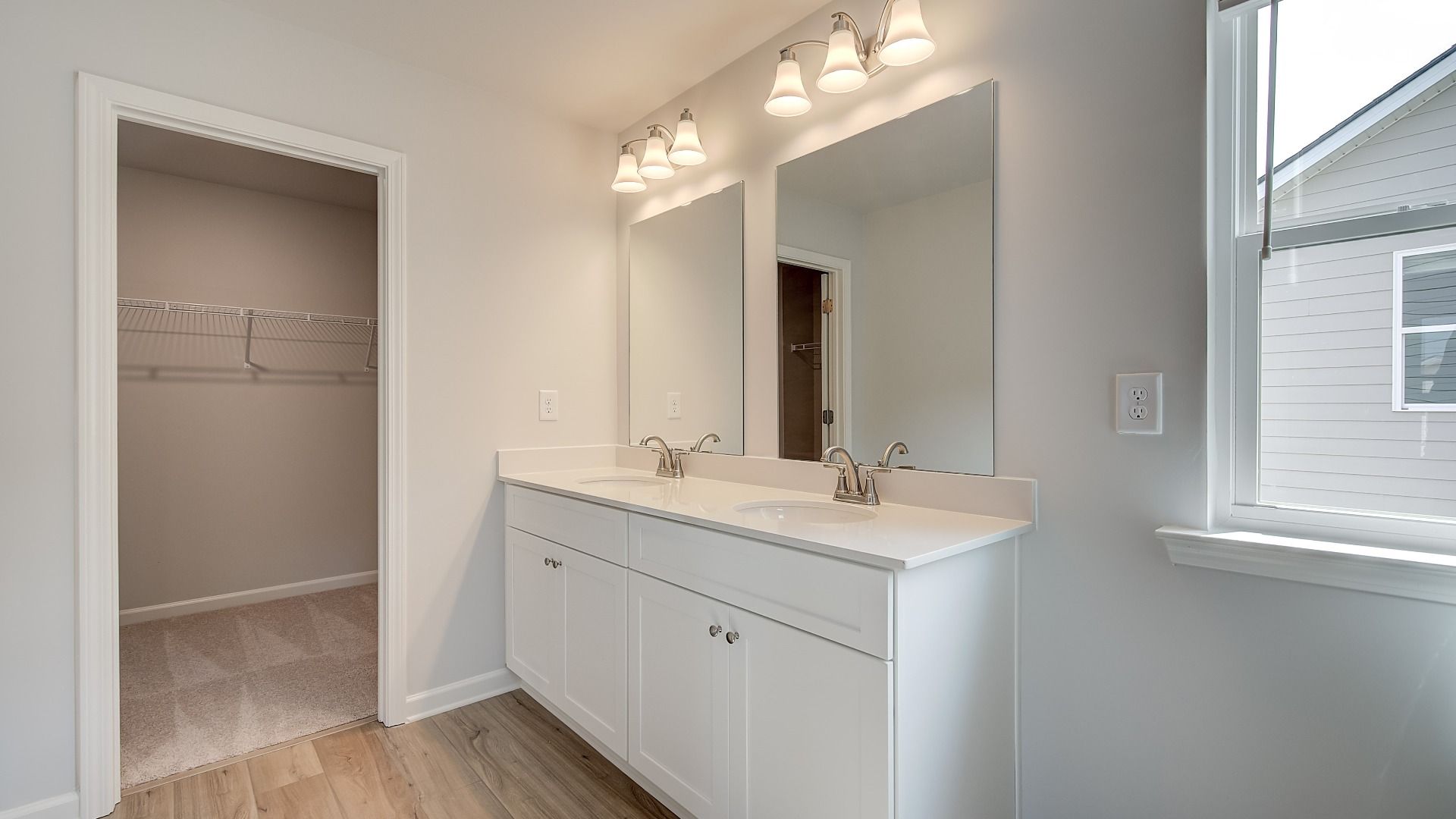 Spacious primary bathroom in Abbotts Crossing with double sinks and quartz countertops.