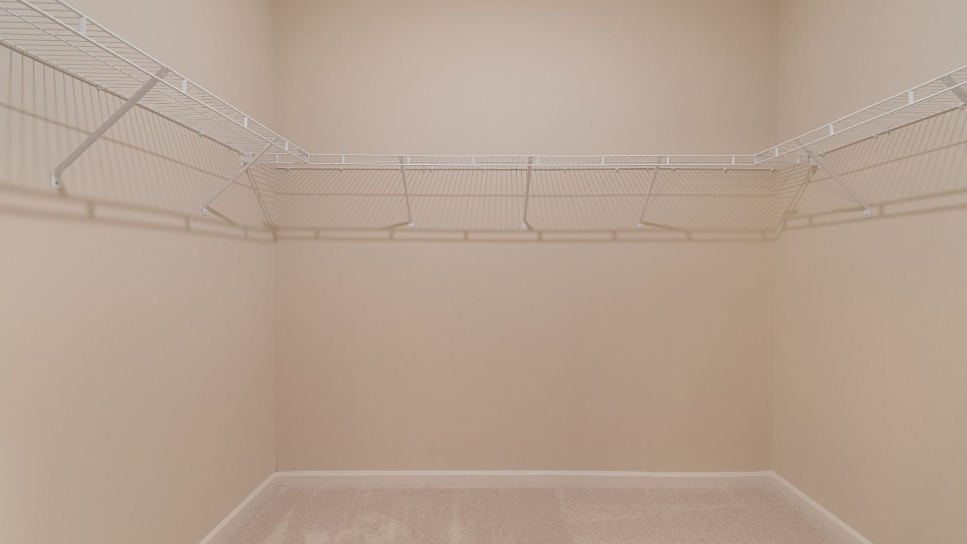Large walk-in closet featuring generous shelving, rods, and storage space for clothing and shoes.