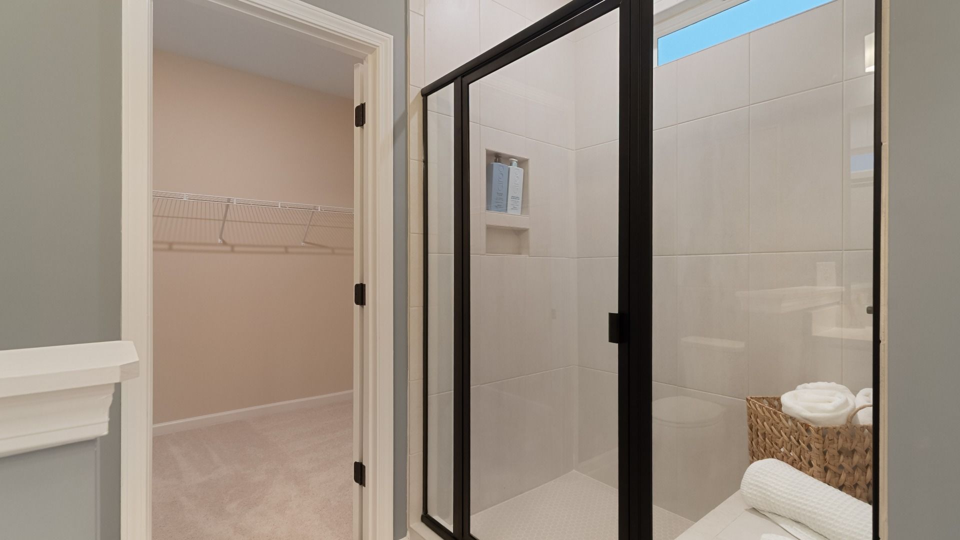 Modern tiled shower with glass door, built-in niche, sleek hardware and built-in bench.