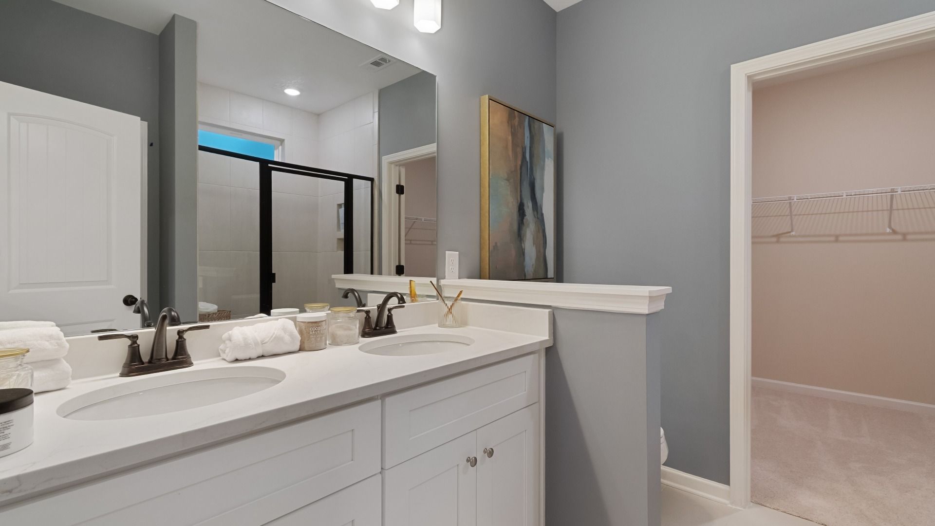Primary bathroom vanity featuring undermount sinks, sleek faucets, and quartz countertops.