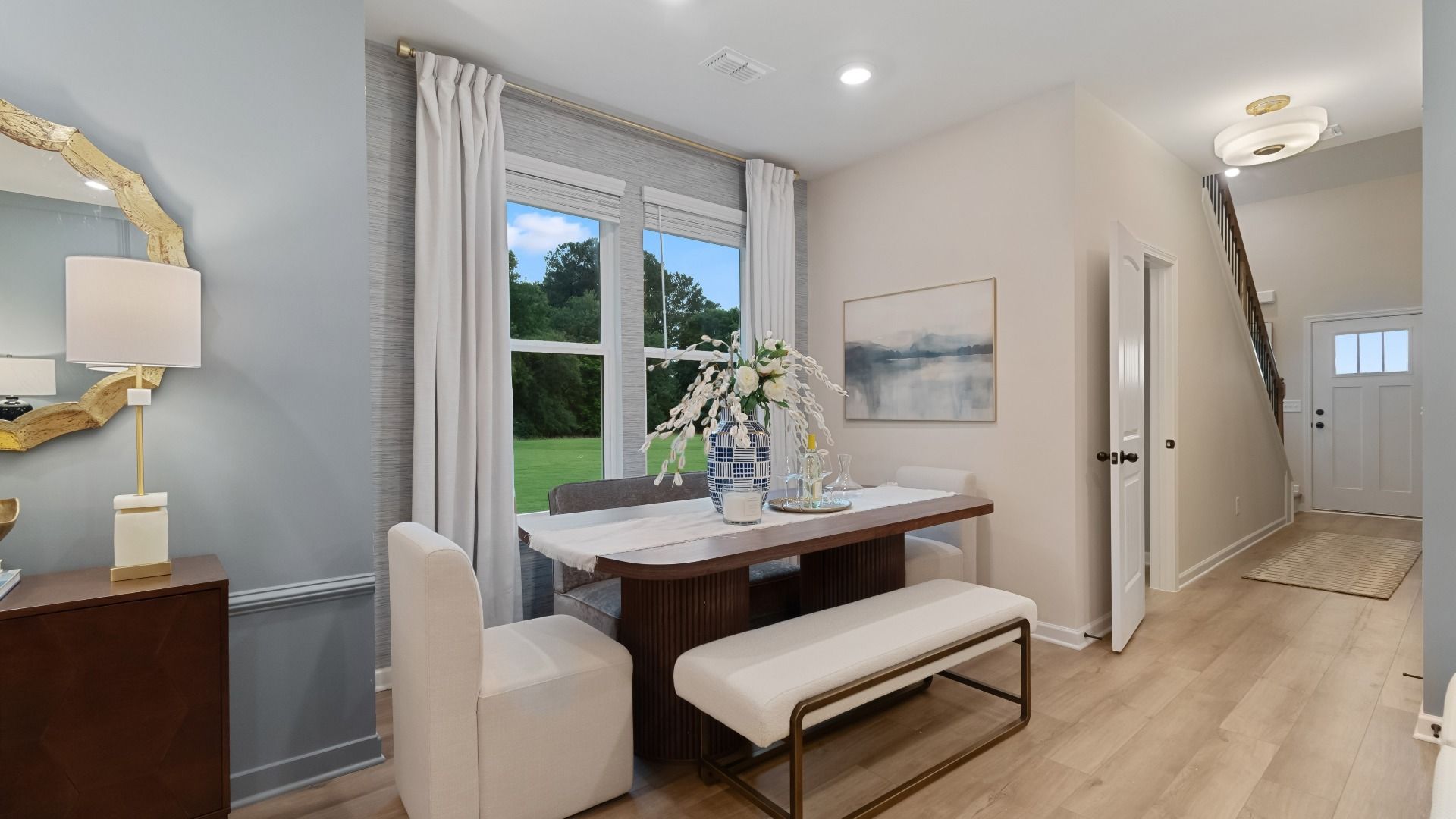 Bright eat-in breakfast area adjacent to kitchen with large windows and space for casual dining.