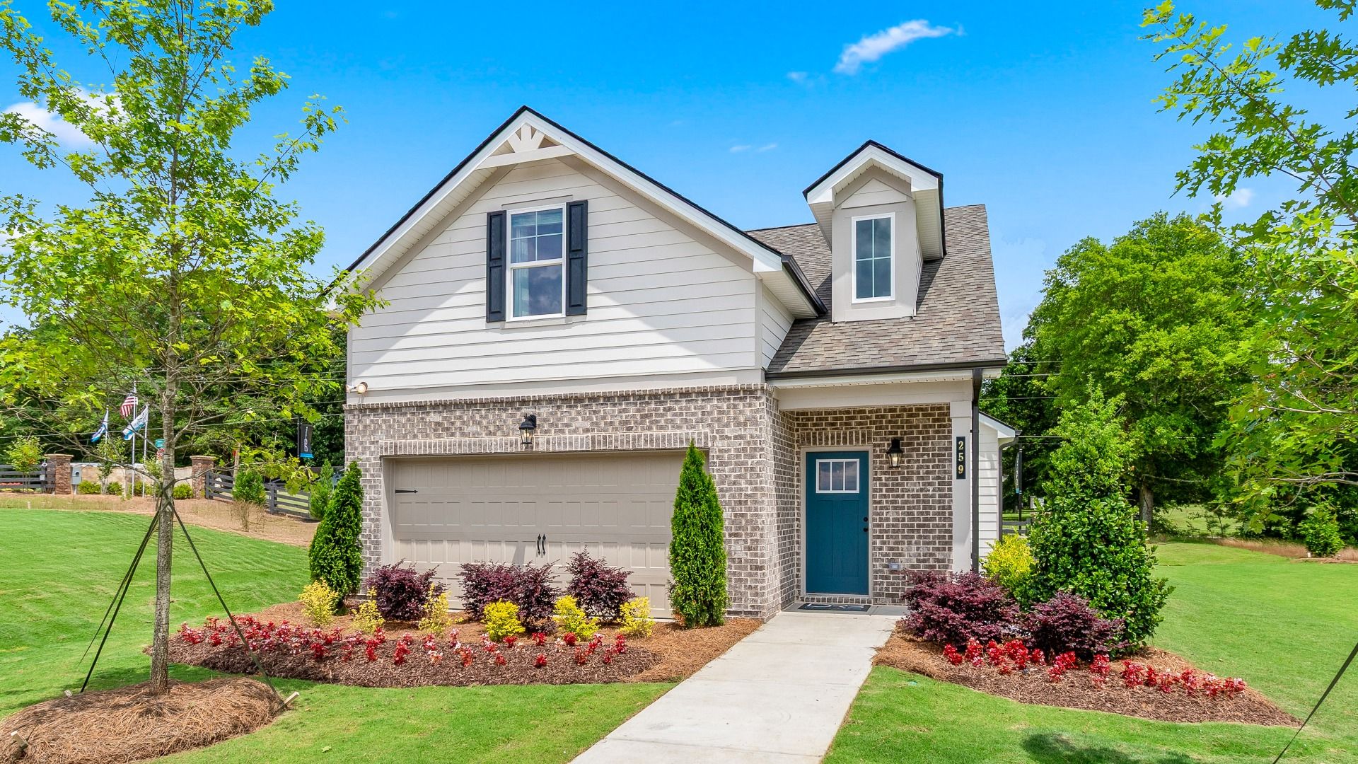 Charming white fiber cement siding and brick accent single family home with blue door by DRB Homes in Conyers, GA