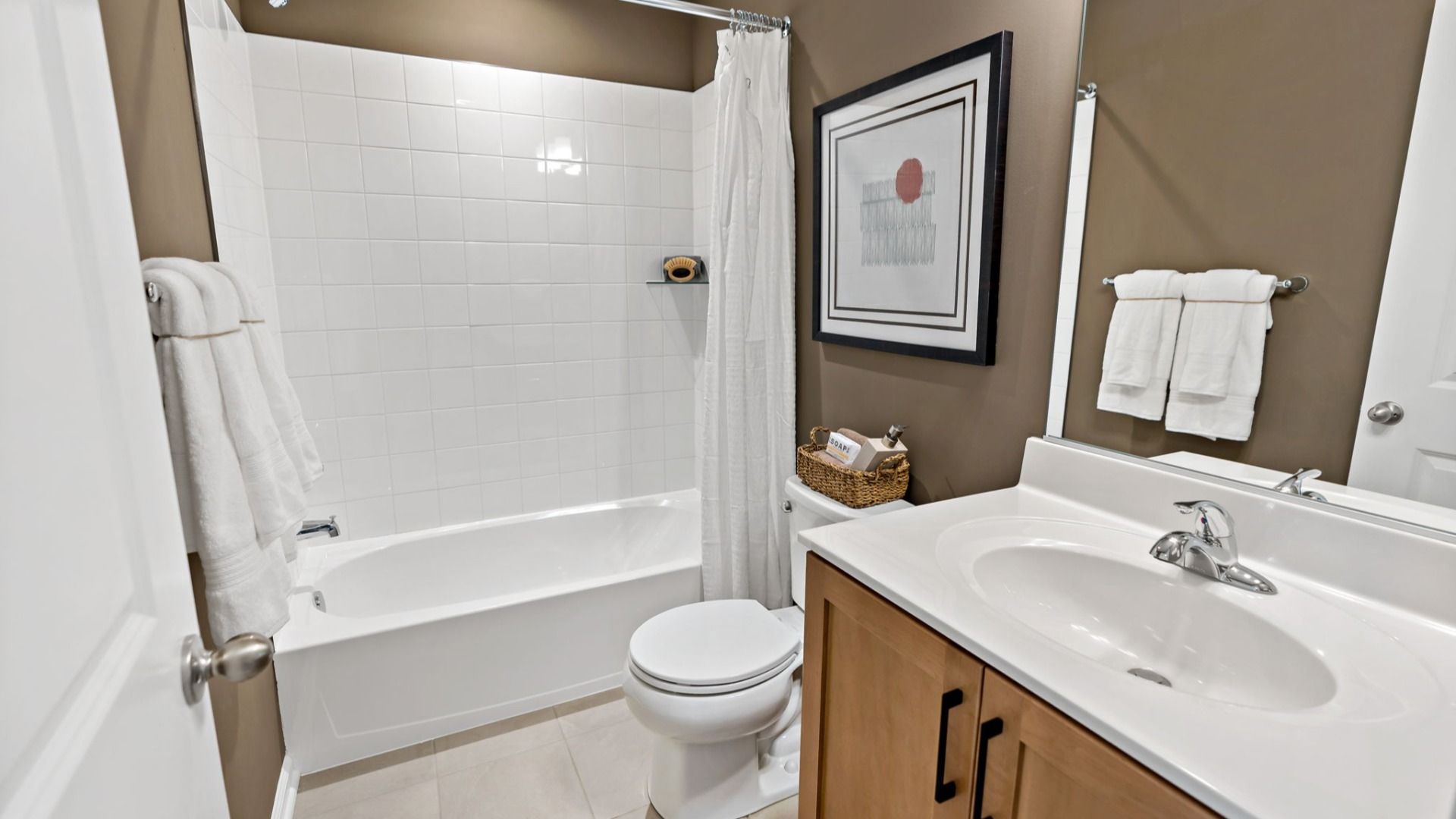 Hall bathroom featuring a sink, shower, toilet, and warm wooden accents.