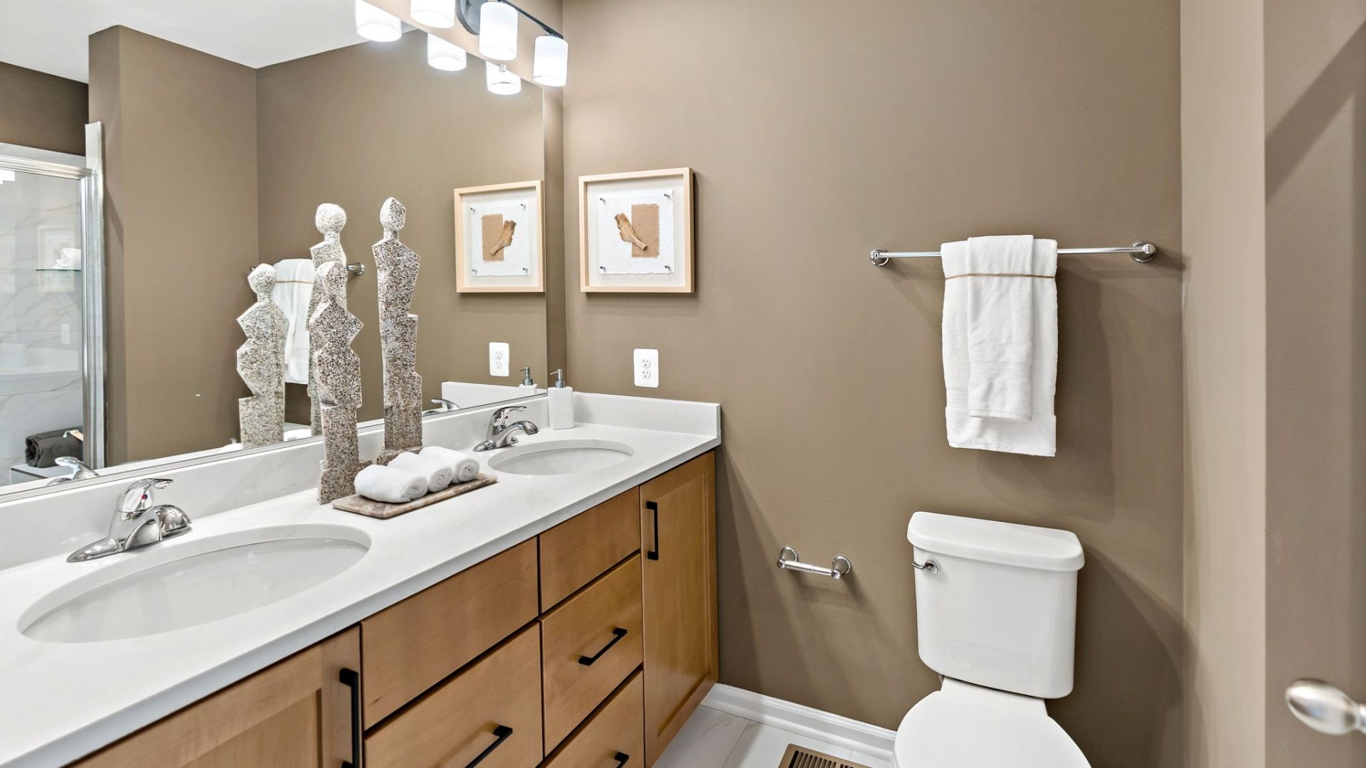 Functional owners bathroom with dual sinks and a large mirror for convenience and style.