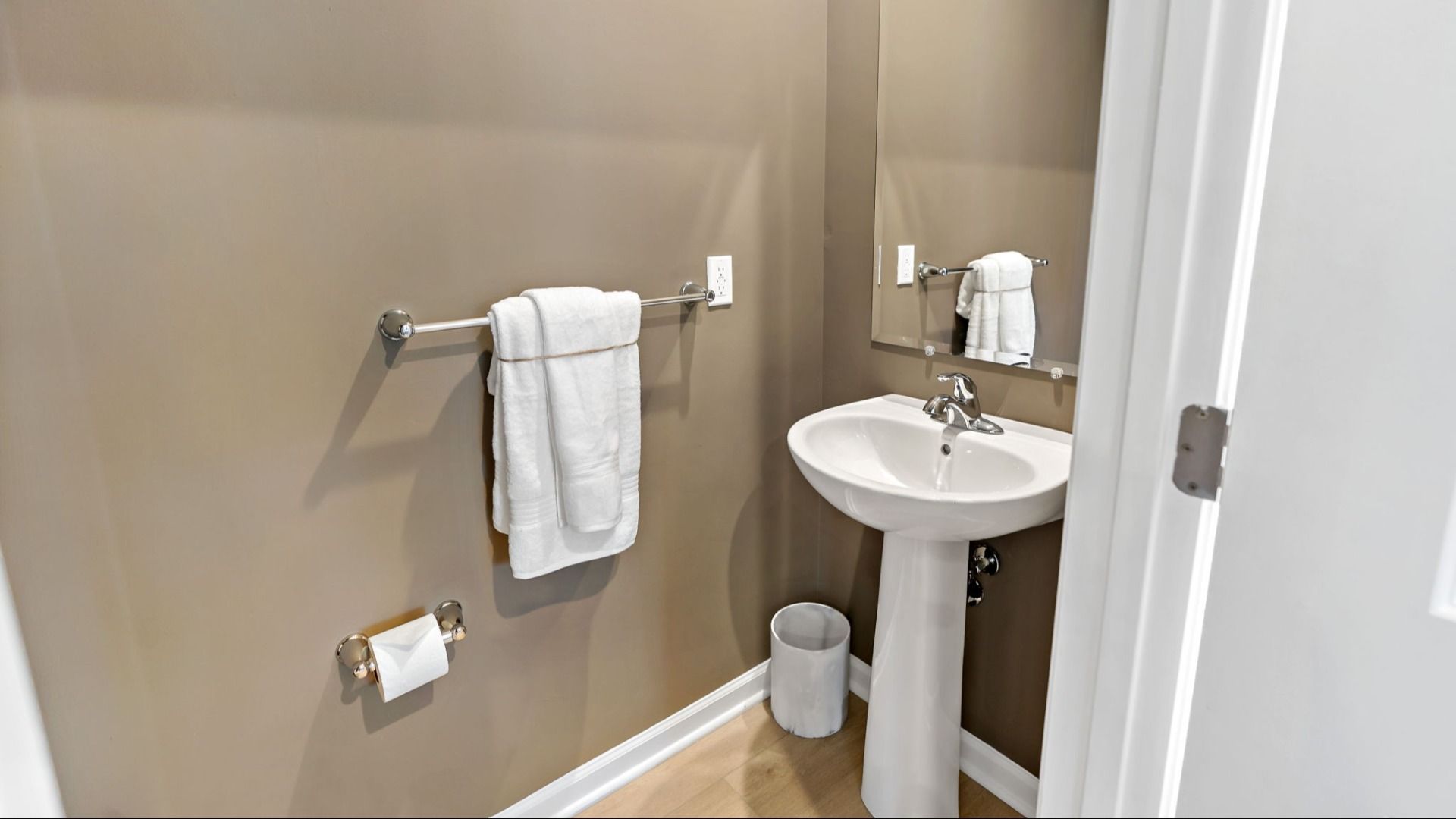 Elegant powder room featuring a pedestal sink and clean, stylish design.