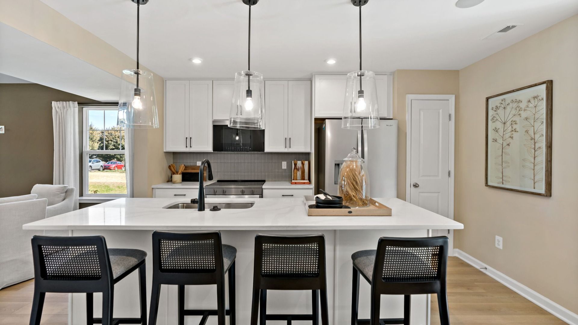 Enjoy cooking and gathering around the kitchen island with bar seating and modern lighting.