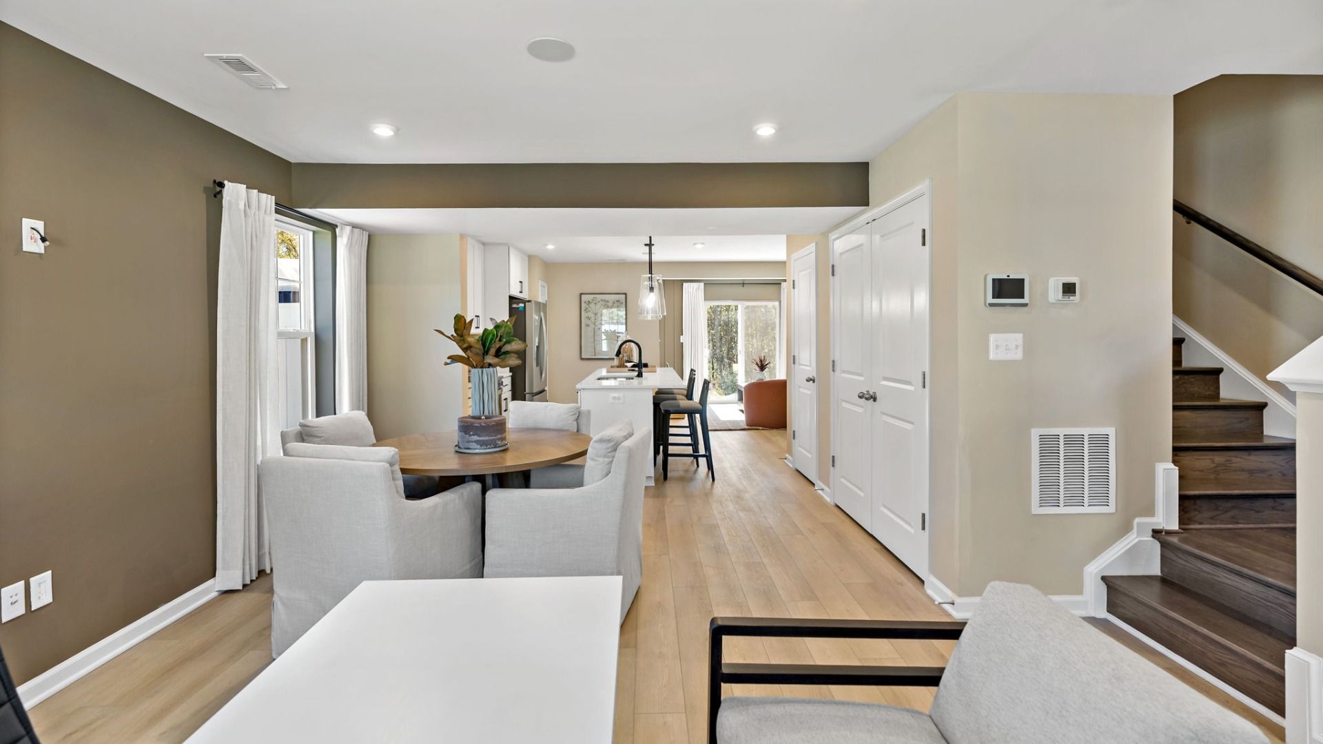 Step into a spacious entryway with stairs and a cozy seating area for welcoming guests.