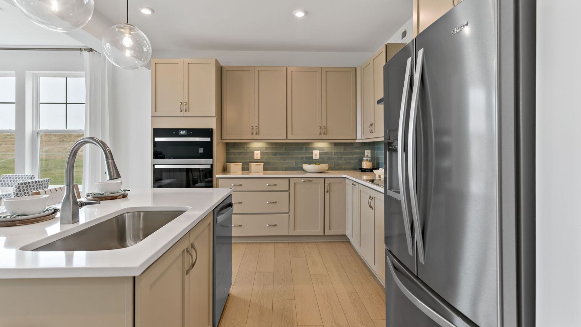 View of the kitchen showcasing a stainless steel sink and dishwasher attached to the island.