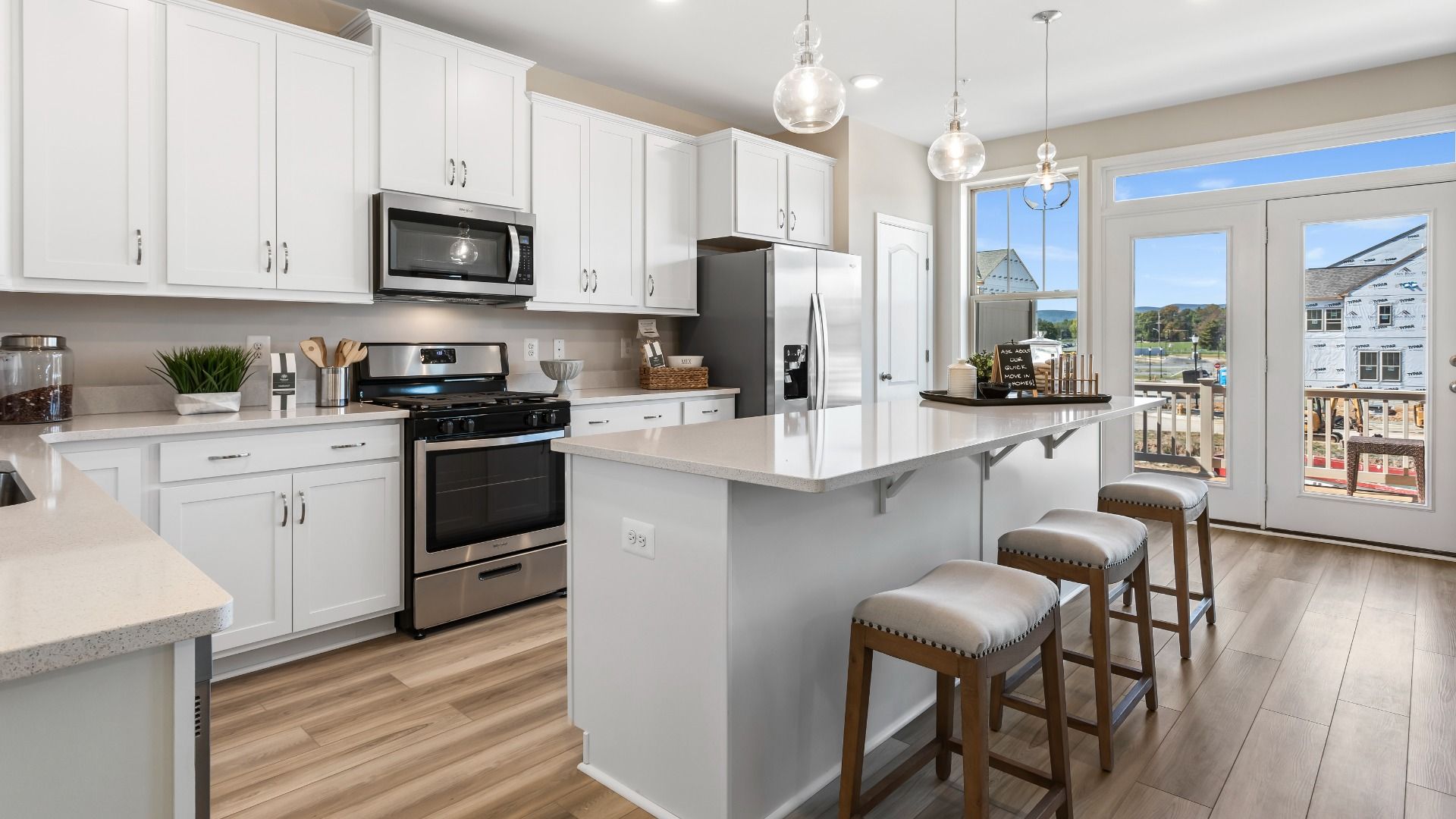 Island kitchen with white cabinets at a DRB Homes Upton II Model at the Canterbury Station Community.
