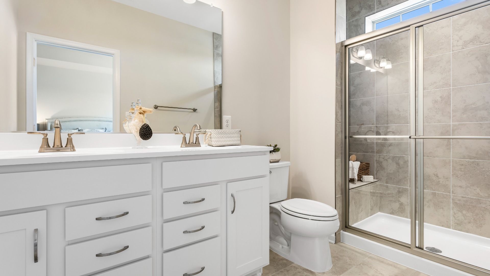 Owner's bath with dual vanity & large step-in tiled shower at a DRB Homes Upton II Model at the Canterbury Station Community.