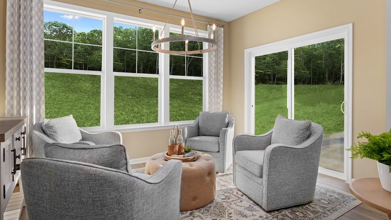 Enjoy the bright morning room in the Starling II, featuring large windows and a sliding glass door.