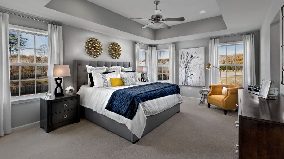 Carpeted owner's suite with tray ceiling in a DRB Homes Newbury II home plan at Huntfield.