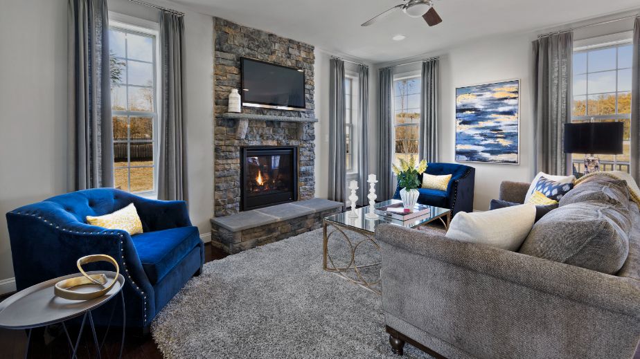 Family room with stone surround fireplace in a DRB Homes Newbury II home plan at Huntfield.