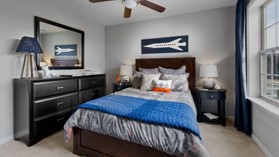 Carpeted secondary bedroom with large window in a DRB Homes Newbury II plan at Huntfield.