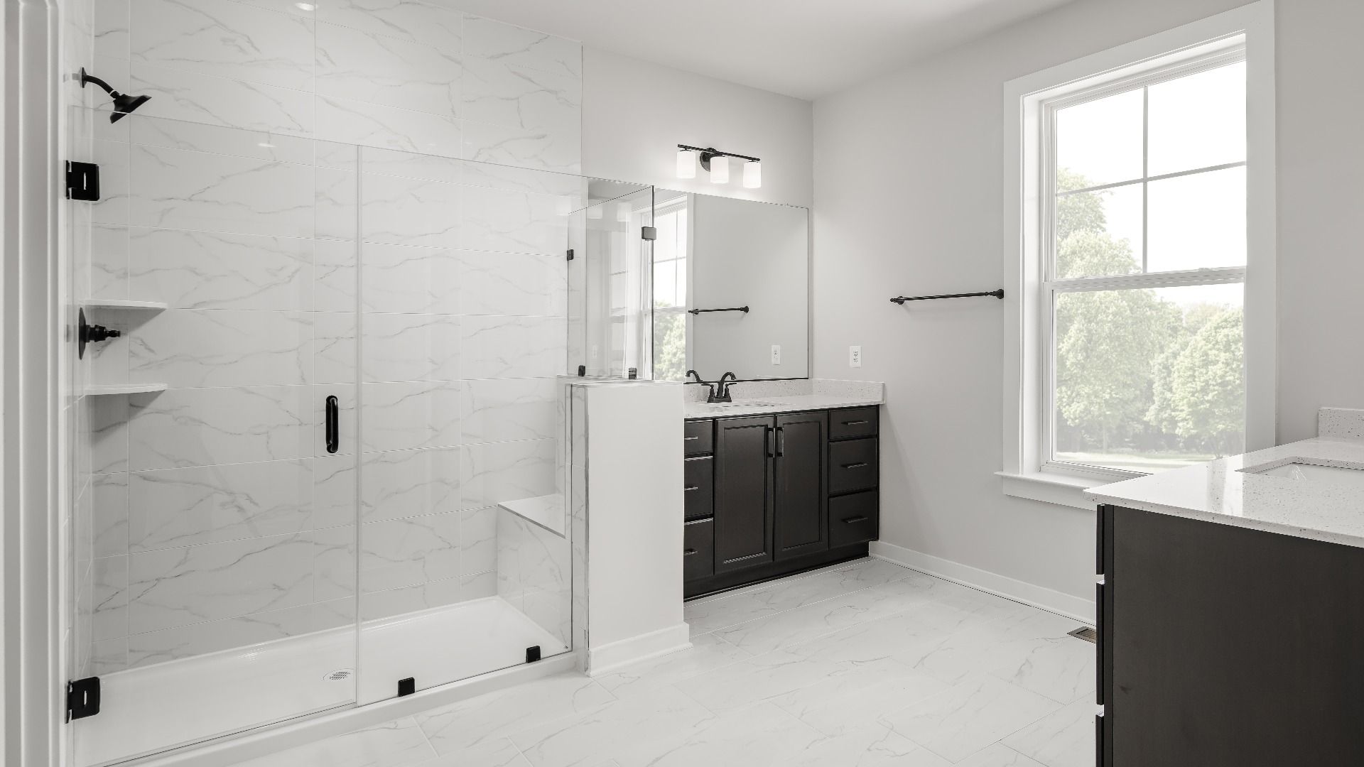 A Spa-Inspired, Luxurious Owner's Suite Bathroom Featuring a Dual Vanity and Seated Shower in the Creighton at South Lake