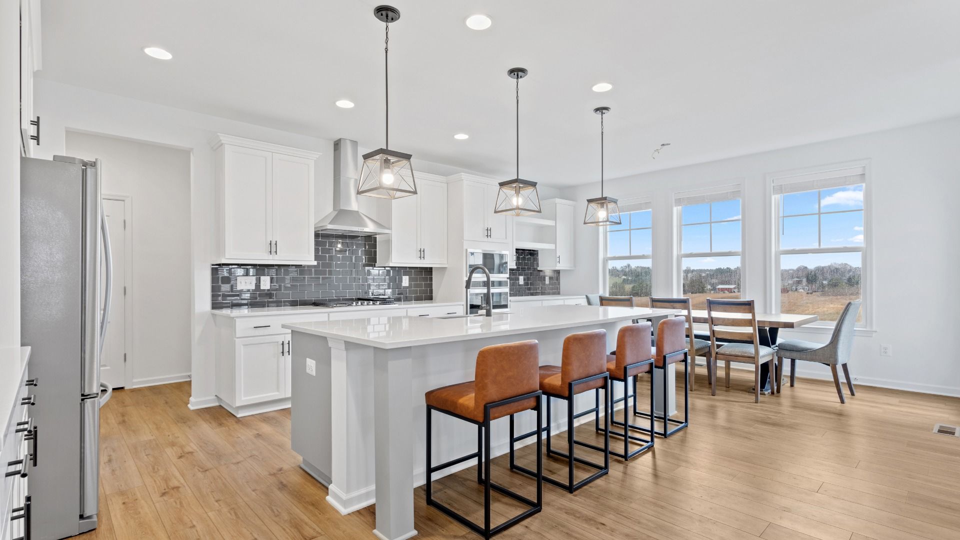 Island kitchen with white cabinets in a DRB Homes Bridgeport home plan at Huntfield in Charles Town, WV