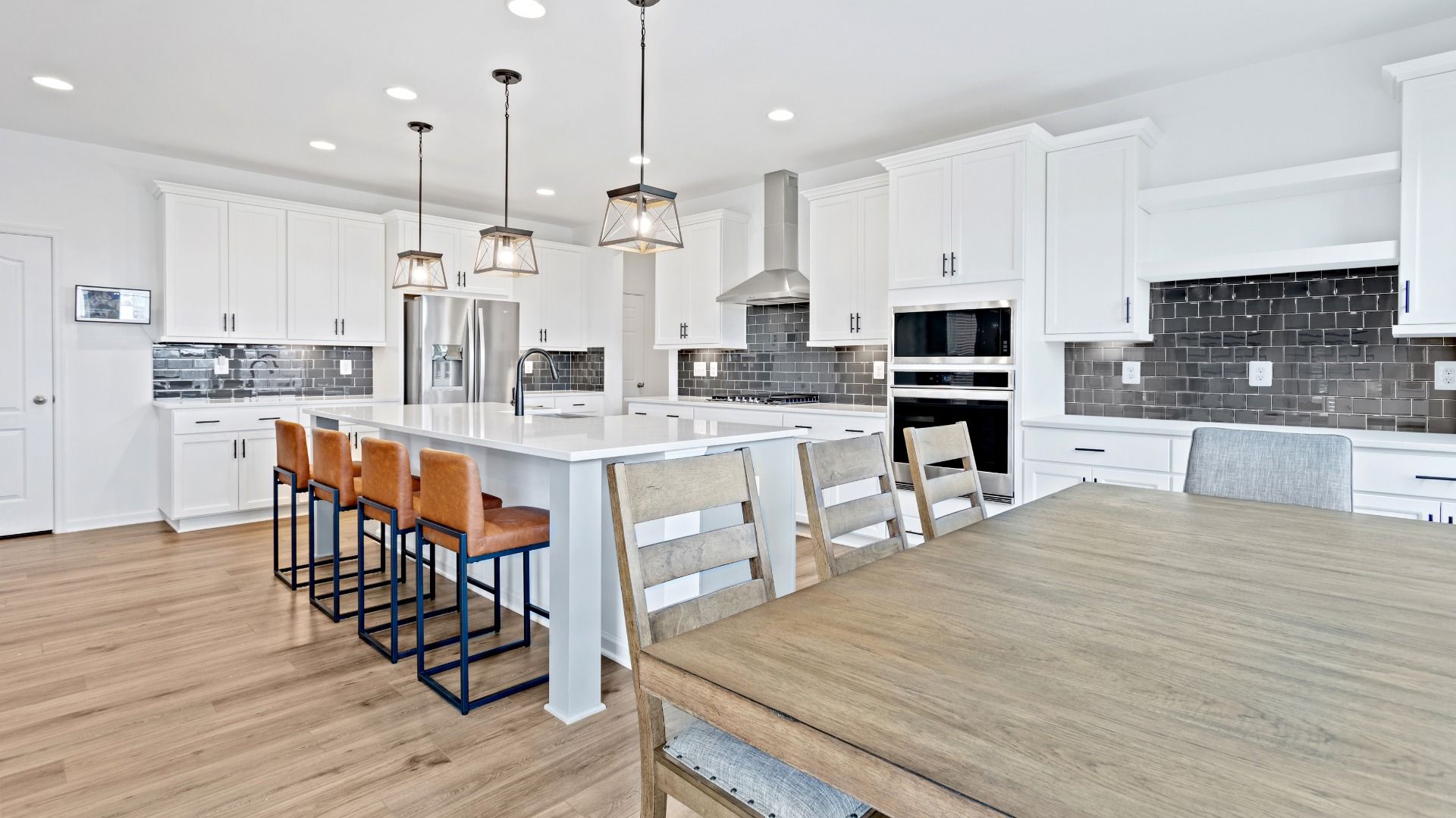 Island kitchen and dining area in a DRB Homes Bridgeport home plan at Huntfield in Charles Town, WV
