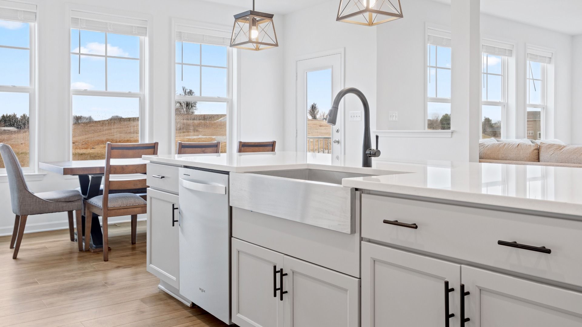 Island kitchen and adjoining dining area in a DRB Homes Bridgeport home plan at Huntfield in Charles Town, WV