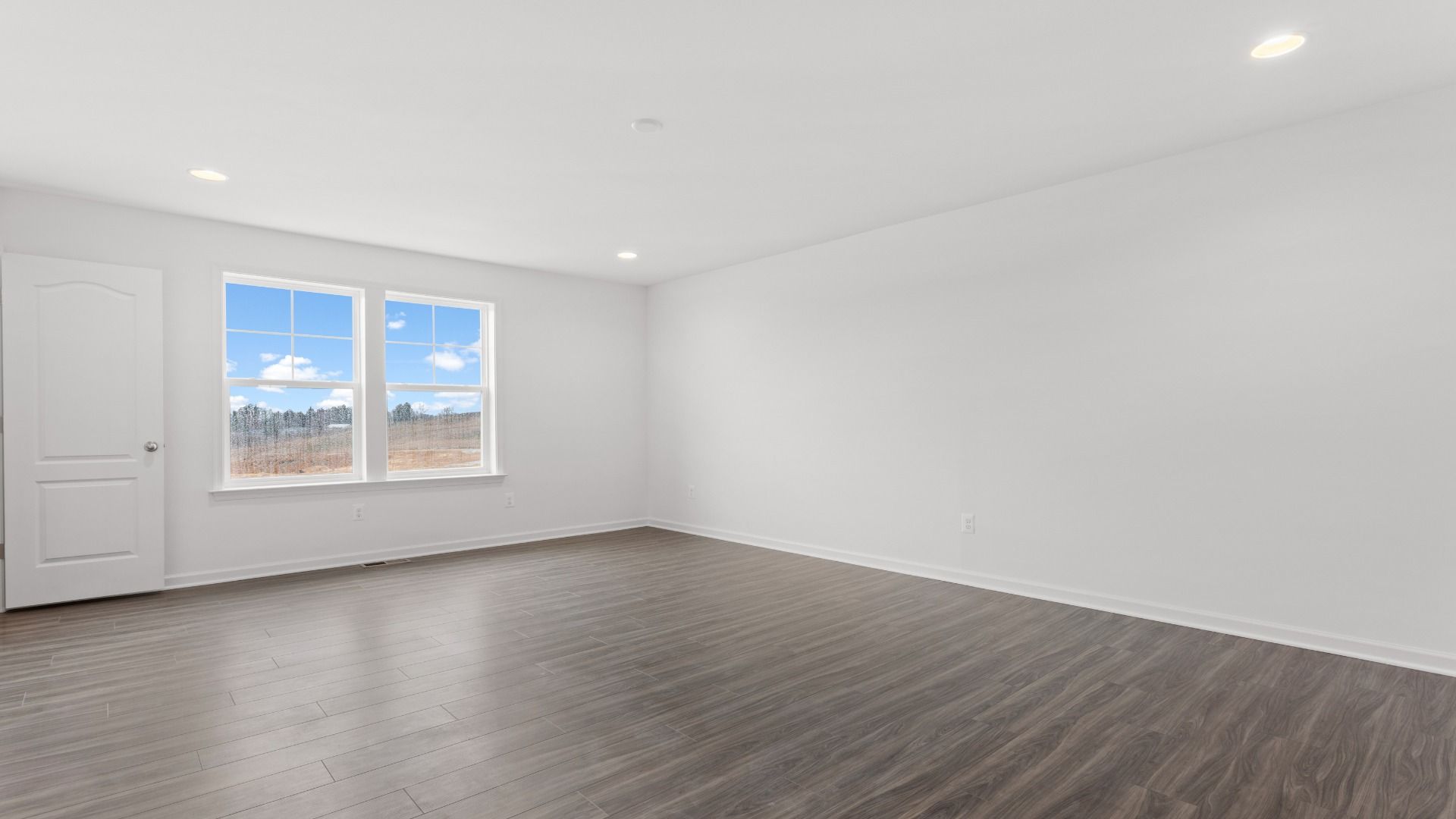 Owner's suite with wood floors and double window in a DRB Homes Bridgeport home plan at Huntfield in Charles Town, WV