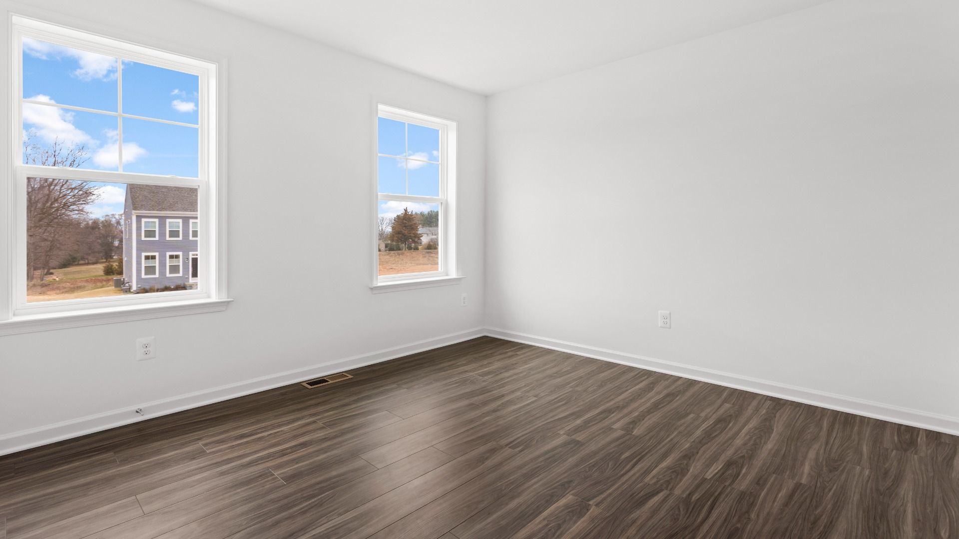 Secondary bedroom with wood floors and 2 windows in a DRB Homes Bridgeport home plan at Huntfield in Charles Town, WV