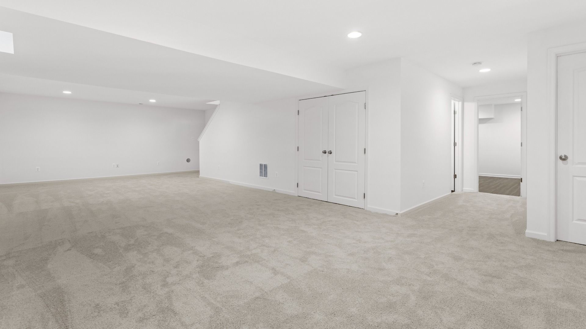 Carpeted lower level in a DRB Homes Bridgeport home plan at Huntfield in Charles Town, WV