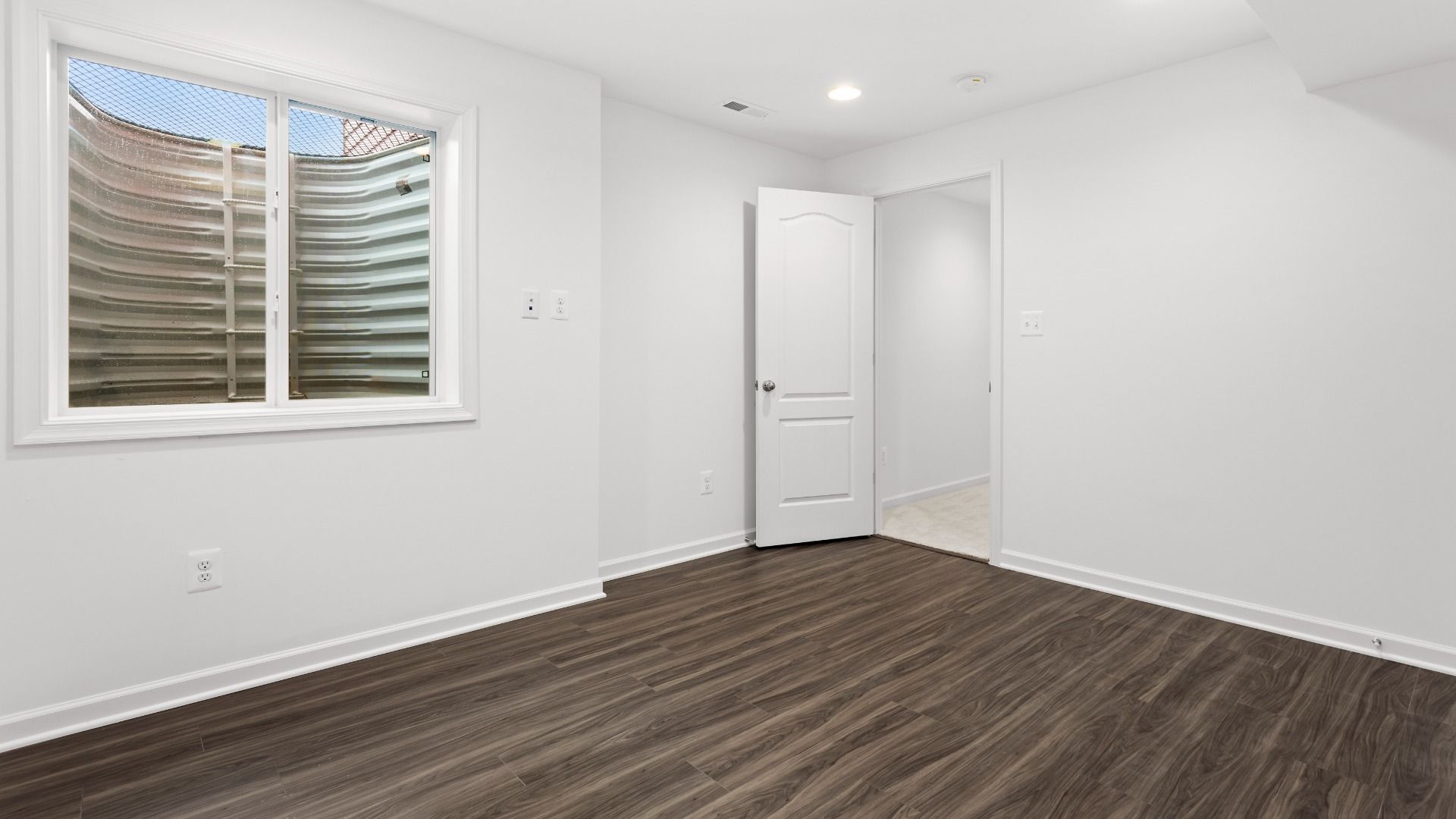 Lower level bedroom with wood floors in a DRB Homes Bridgeport home plan at Huntfield in Charles Town, WV