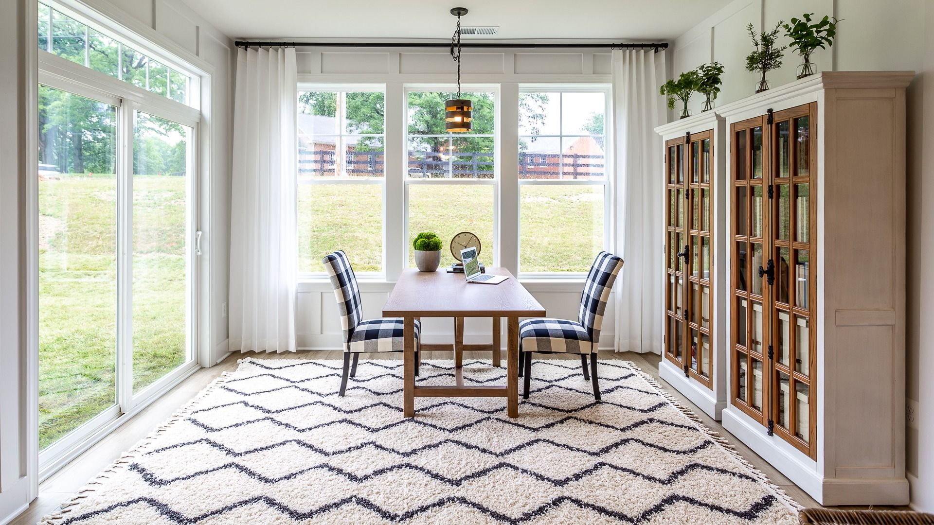 The Optional Sunroom with Bookshelves and a Seating Area in the DRB Homes Finch Model at Rosehill Manor