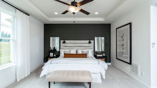 The Owner's Suite with a Queen-Sized Bed and Tray Ceiling in the DRB Homes Finch Model at Rosehill Manor