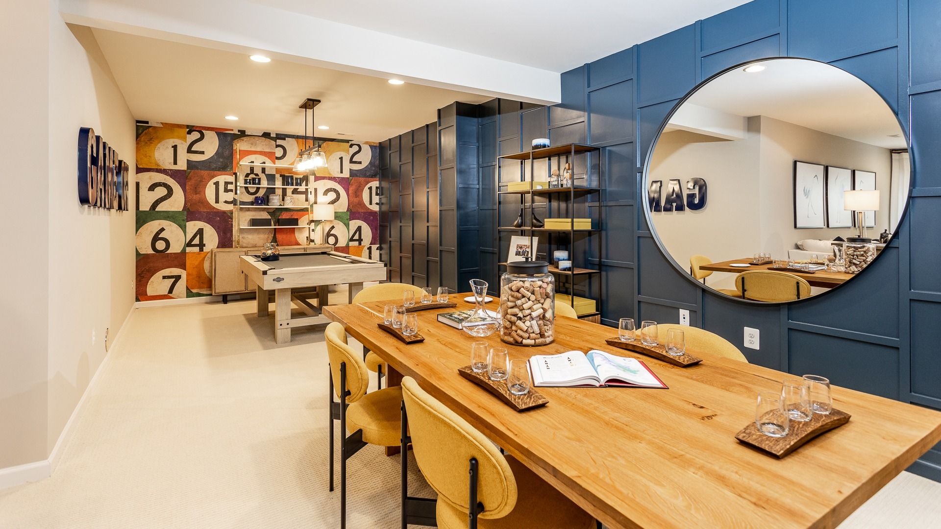 Finished lower level with a pool table and dining area, perfect for hosting in Clemson II floor plan.