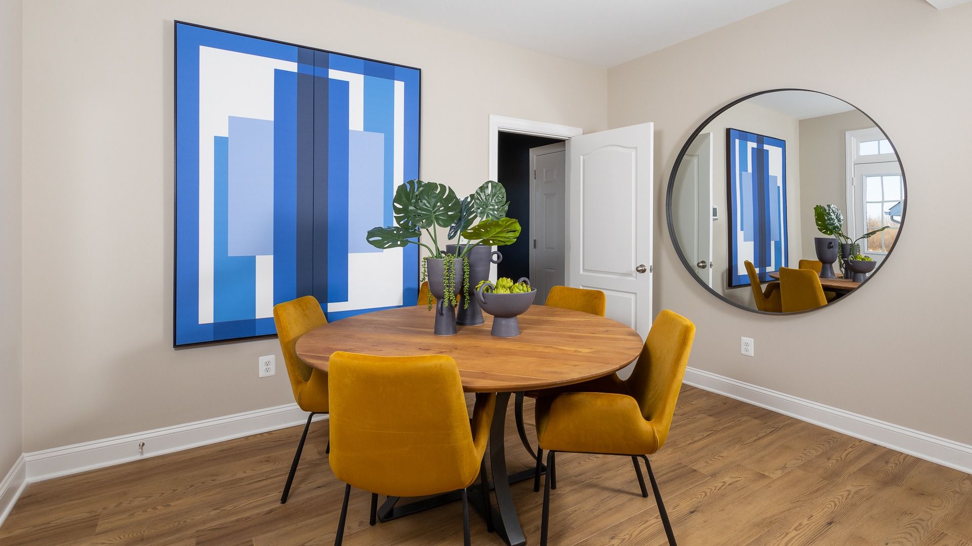 The breakfast area in the Clemson II floor plan features a stylish round table with five chairs.