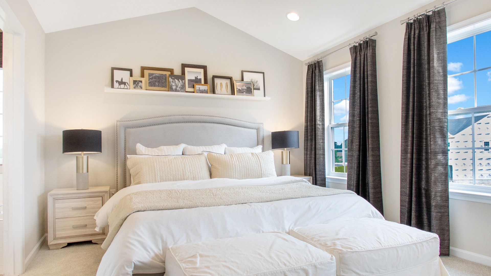 Carpeted owner's suite with vaulted ceiling and 2 large windows in a DRB Homes Cypress II at Huntfield.