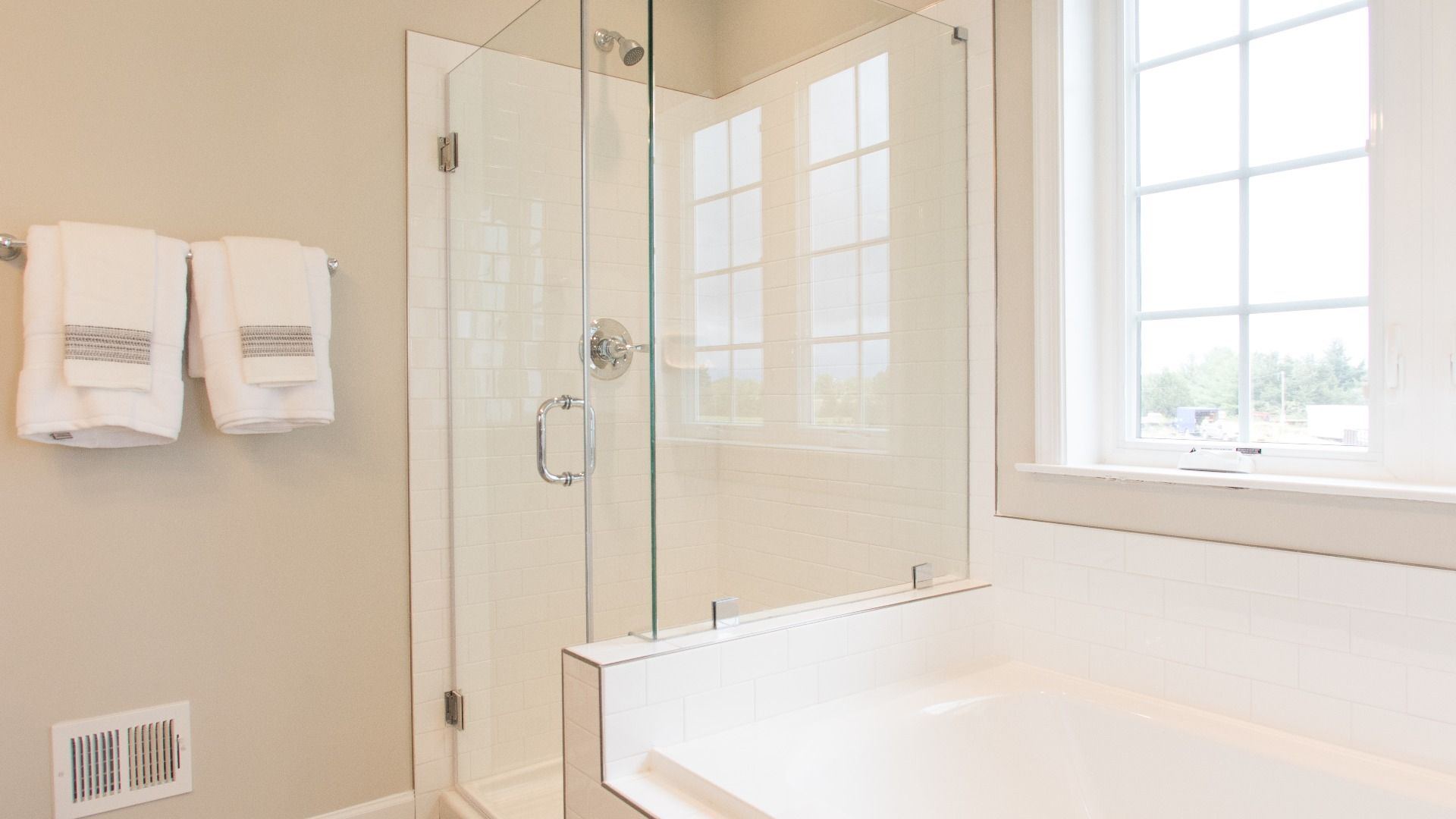 Owner's bath with separate shower/tub and large window in a DRB Homes Cypress II home plan at Huntfield.