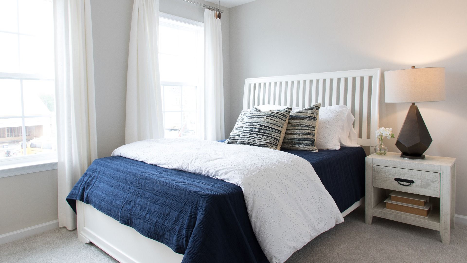 Carpeted secondary bedroom with 2 large windows in a DRB Homes Cypress II at Huntfield.