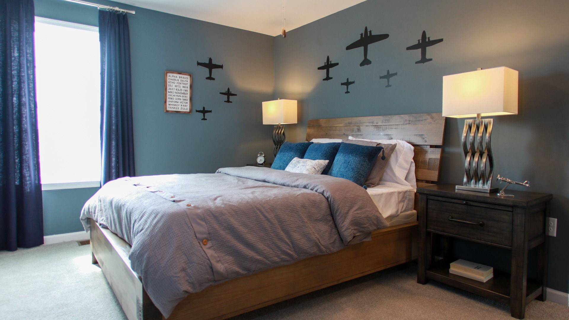 Carpeted secondary bedroom with large window in a DRB Homes Cypress II at Huntfield.